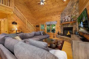 a living room with a couch and a fireplace at Blue Line Vista - Private Cabin Ellijay GA - Hot Tub, Game Room, Fire Pit, Private Balcony, Outdoor Dining - Ellijay, GA in Ellijay