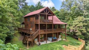 a cabin in the woods with a red roof at Blue Line Vista - Private Cabin Ellijay GA - Hot Tub, Game Room, Fire Pit, Private Balcony, Outdoor Dining - Ellijay, GA in Ellijay