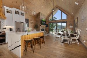 eine Küche und ein Esszimmer mit Tisch und Stühlen in der Unterkunft Elevated Escape - Luxurious Mountain Views - Hot Tub, Game Room, Fire Pit, Full Mountain Views - Escape to Luxury North Georgia in Cherry Log