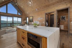 eine Küche mit Herdplatte in einem Raum mit Fenstern in der Unterkunft Elevated Escape - Luxurious Mountain Views - Hot Tub, Game Room, Fire Pit, Full Mountain Views - Escape to Luxury North Georgia in Cherry Log + 82 Fotos