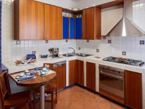 a kitchen with wooden cabinets and a table and a sink at BnB Anna e Leo - Casa di Leo in Pietra Montecorvino
