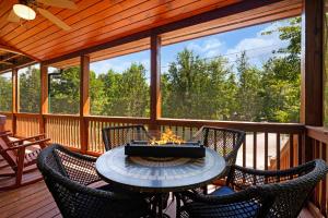 a patio with a table and chairs on a porch at Escape to Dream Catcher - Enjoy cozy accommodations, and a variety of entertainment options including a hot tub, game room, and in Blue Ridge