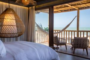 1 Schlafzimmer mit einem Bett und einem Balkon mit einer Hängematte in der Unterkunft Yemanjá Hotel by Preabeach Experience in Prea