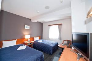Postel nebo postele na pokoji v ubytování Hotel Unisite Sendai