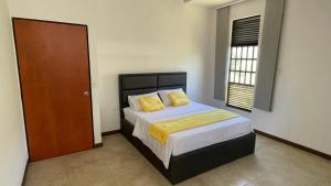 een slaapkamer met een bed met twee gele kussens bij Hospedaje El Caminante CAPI in Capitanejo