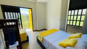 een slaapkamer met twee bedden en een groot raam bij Hospedaje El Caminante CAPI in Capitanejo