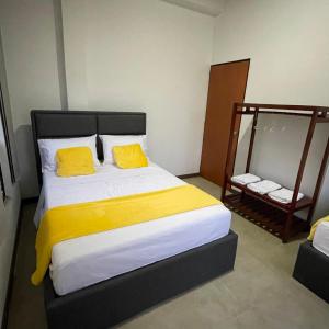 a bedroom with a large bed with two yellow pillows at Hospedaje El Caminante CAPI in Capitanejo +8 photos