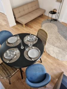a dining room table with plates and wine glasses on it at Menton centre Cosy and spacious in Menton