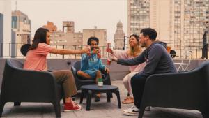 a group of people sitting on a rooftop drinking at Viajero Montevideo Hostel in Montevideo