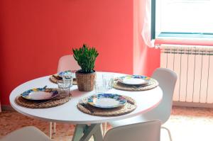 a white dining room table with plates on it at Casa Ninetta Caprarola in Caprarola