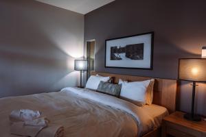 a bedroom with a large bed with two lamps at Lakefront Mountain View - Resort Loft in Lac-Superieur