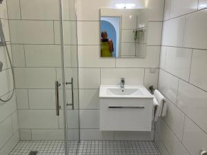 a white bathroom with a sink and a mirror at Ferienwohnung Sieben, Zentral gelegene mit Tiefgaragenstellplatz in Bad Oeynhausen +16 photos