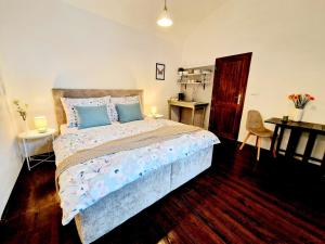 a bedroom with a bed with blue pillows and a desk at Helena Old Town Apartment in Košice +11 photos