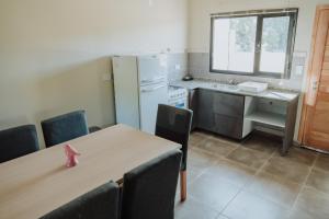 a kitchen with a table with chairs and a refrigerator at Las Loicas Tempo in Esquel +8 photos