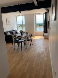 un soggiorno con tavolo, sedie e divano di Appartement neuf, vue sur saône a Mâcon