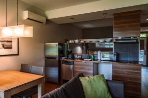 a kitchen with a table and a counter top at Lakefront and Mountain View - Resort Loft in Lac-Superieur +44 photos
