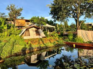 a house sitting on the side of a river at Mầm Farmstay And Camping in Lam Ha