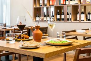 a table with a plate of food and wine glasses at Holiday Inn Beja by IHG in Beja +76 photos