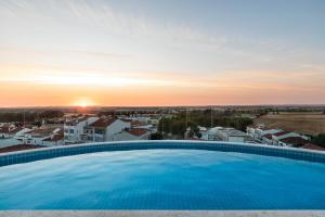 a large swimming pool with the sunset in the background at Holiday Inn Beja by IHG in Beja