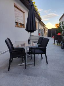 a table with chairs and an umbrella on a patio at Nationalpark Apartments in Apetlon