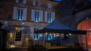 a blue umbrella in front of a building at night at Sylo-V CHAMBRE EDGAR in Gensac-la-Pallue