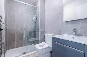 a bathroom with a toilet and a sink and a shower at Elysée Suites - Spacious 1 Bed Flat in Southport in Southport
