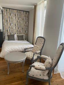 Un dormitorio con una cama y dos sillas y una mesa. en Sylo-V CHAMBRE EDGAR, en Gensac-la-Pallue