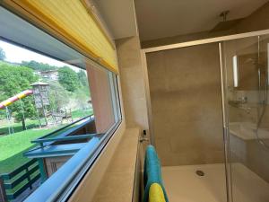 bagno con doccia e ampia finestra di Pension Ahorn a Saalbach Hinterglemm