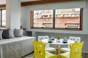 a living room with a table and yellow chairs at Departamento 110 - Edificio VILAUT by INMOVE Temporarios in Córdoba