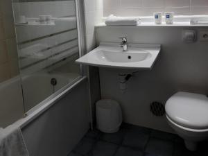 a bathroom with a sink and a toilet and a shower at Ibis Budget Bourgoin Jallieu Centre in Bourgoin