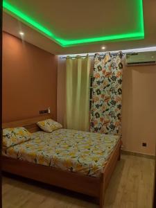 洛美Clarisse Lodge Rez的一间卧室配有一张绿灯床