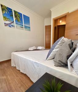 a bedroom with a large bed with white sheets at THE HOUSE IN TOQUERO Solarium views to the Alcazaba in Málaga