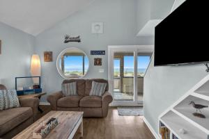 salon z kanapą i telewizorem w obiekcie Another Beach Experience by Oak Island Accommodations w mieście Oak Island