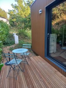 a patio with a table and chairs on a deck at Tiny house dans l'ouest lyonnais in Sain-Bel