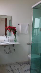 a bathroom with a sink and a vase of flowers at Pousada Santa Rita in Paraty