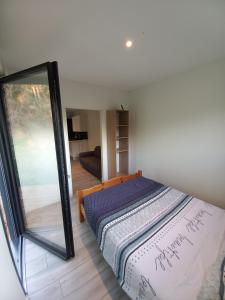a bedroom with a bed and a mirror at Tiny house dans l'ouest lyonnais in Sain-Bel