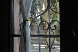 una ventana con una cortina en blanco y negro en Posada de la Flor, en Colonia del Sacramento