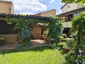 a garden with a pergola with blue flowers at Los Colmenares in Cuzcurrita-Río Tirón