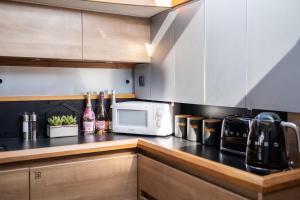 a kitchen with a counter top with a microwave at 2BR Heated Yacht, Lymington Centre, Beautiful View in Lymington +15 photos