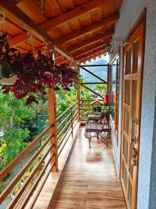 a balcony of a house with a table and chairs at Woody Trails - Astronomy, Graphology, Family, Kainchi Dham in Bhowāli