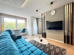a living room with a blue couch and a tv at Franca-free parking in Sarajevo