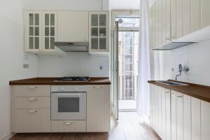 a kitchen with white cabinets and a stove top oven at Piazza di Spagna Historic Flat in Rome