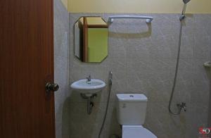 ein Badezimmer mit Toilette, Waschbecken und Spiegel in der Unterkunft Hamogaway Homestay - Tourism Road in Maasin