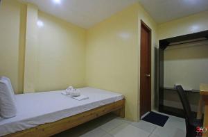 ein kleines Zimmer mit einem Bett und einem Stuhl in der Unterkunft Hamogaway Homestay - Tourism Road in Maasin