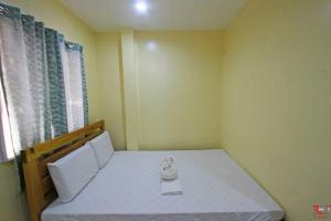 ein kleines Schlafzimmer mit einem weißen Bett und einem Fenster in der Unterkunft Hamogaway Homestay - Tourism Road in Maasin + 7 Fotos