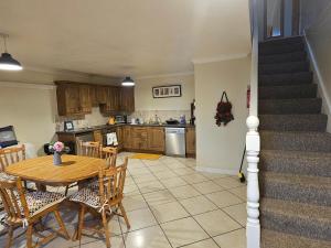 a kitchen and dining room with a table and a staircase at Oceanside Golf and Beach in Downings