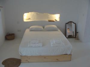 a bedroom with a bed with white sheets and a mirror at Casas Velhinhas - Apartº Aconchego e Apartº Calmaria in Estremoz +27 photos