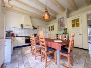 a kitchen with a wooden table and chairs at Bronzigt in Sluiskil