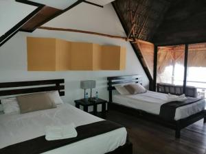 une chambre avec deux lits dans une pièce dans l'établissement Hotel Guapinol, à Marisco Guapinol