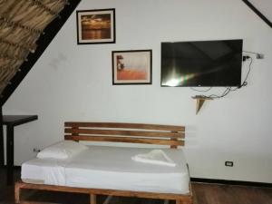 une chambre avec un lit et une télévision à écran plat dans l'établissement Hotel Guapinol, à Marisco Guapinol
